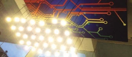A brightly lit chandelier with a circuit board design.