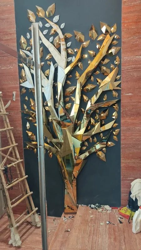 Close up of a metallic tree artwork with silver and gold leaves.