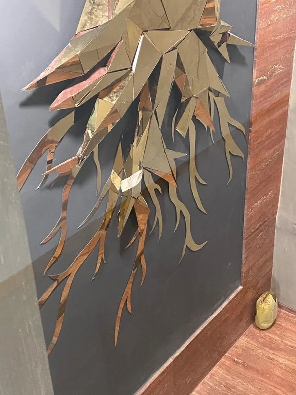 Close up of the metallic, sharp-edged roots of the tree artwork.